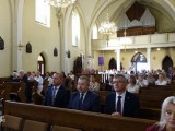 Grupa osób na ławkach w kościele