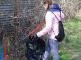 Nastolatka z workiem i chwytakiem zbiera śmieci 