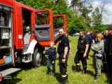 Strażak prezentuje chłopcu wóz strażacki