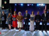 Przewodniczący Rady Powiatu Dębickiego i Członek Zarządu Powiatu Dębickiego z nagrodzonymi osobami przed sceną