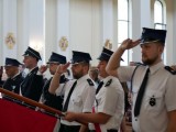 Strażacy w mundurach ze sztandarem w kościele