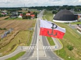 Flaga biało-czerwona z symbolem Polski Walczącej na maszcie, ujęcie z drona