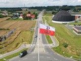 Flaga biało-czerwona z symbolem Polski Walczącej na maszcie, ujęcie z drona