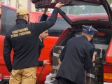 Strażacy ładują agregat prądotwórczy do auta