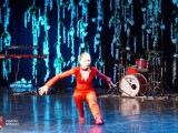 Tancerka w czerwonym stroju w dynamicznej pozie na scenie